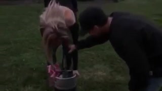 Blonde girl upside down keg stand spits out