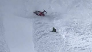 Snowmobile Rider Takes a Spill Down the Hill