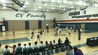 Guy spikes a volleyball and hits opponent in the face in school gym