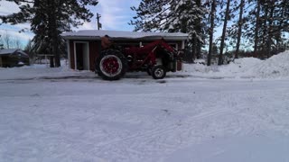 Moving snow with the Farmall M Tractor.