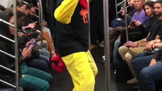 Person chicken costume dancing subway pole