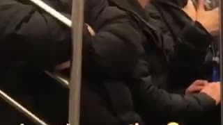 Man wearing batman mask costume casually talks to subway passenger