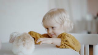 A Little Girl Looking at a Bunny Playing