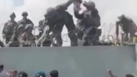 This video shows a toddler being handed over the Kabul airport wall to US troops