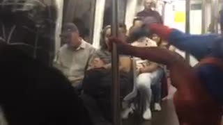Man spiderman outfit dancing subway pole