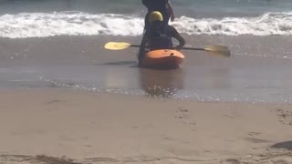 Orange kayak beach wave flip