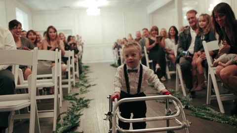 Boy with Down Syndrome walks aisle as ring bearer