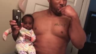 Multitasking dad shows us how he brushes his teeth while holding the baby