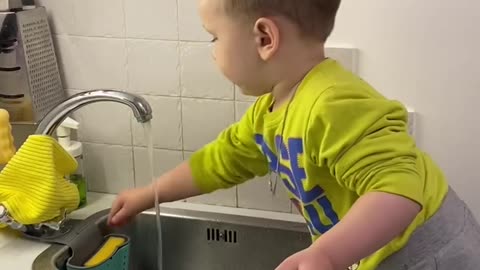 The guy washes the plate behind him