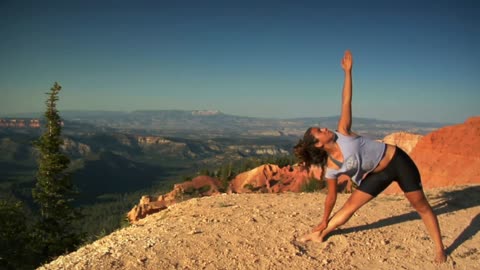 Woman stretching near a cliff
