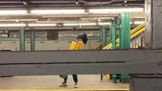 Man yellow jacket dancing subway platform