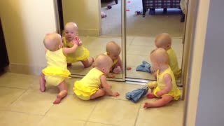 Triplets playing with mirror