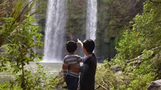 Father and child with watching the waterfalls