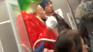 Man on subway train wearing frog mask with red tuxedo