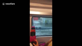 Train passes through flooded station after severe storm hits Paris area
